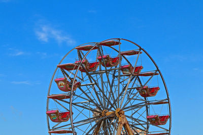 Low angle view of ferris wheel against clear blue sky