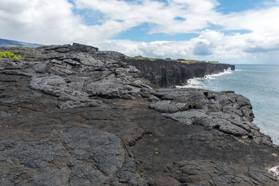 Rock formation on beach against sky