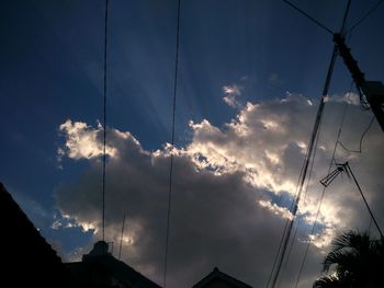 Low angle view of silhouette electricity pylon against sky