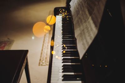 High angle view of illuminated string lights over piano at home