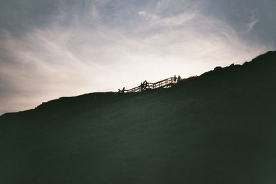 Low angle view of mountain against cloudy sky