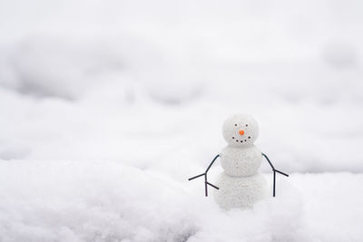 A happy snowman on the street staying in the snow, white background with copy space