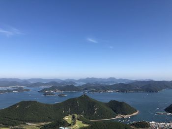 Scenic view of sea and mountains against blue sky