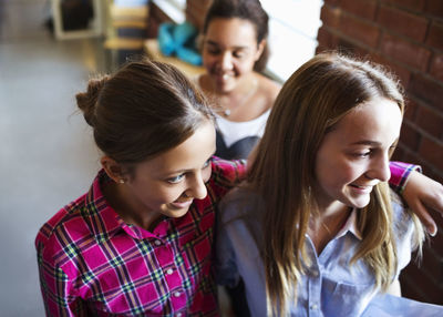 High angle view of smiling schoolgirls at corridor