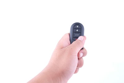 Close-up of hand holding camera over white background