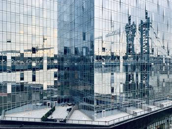 Glass facade of tall buildings in city reflecting manhattan bridge in nyc