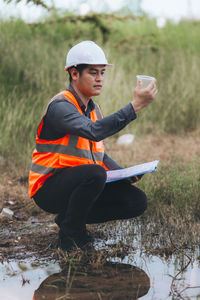 Side view of young man standing on field