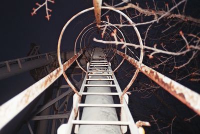 Directly below shot of ladder against sky at night