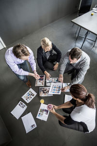 High angle view of business colleagues discussing over photographs in office