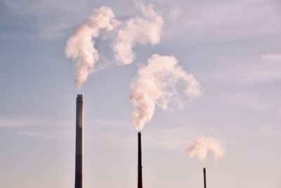 Smoke emitting from chimney against sky