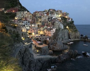 Buildings by sea against sky in city