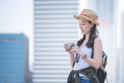 Young woman wearing hat while standing outdoors