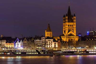 Illuminated buildings against sky at night