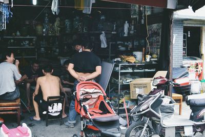 Rear view of people standing at store