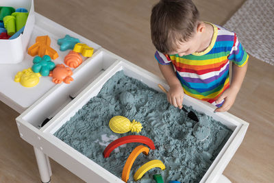 High angle view of boy playing on table