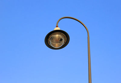 Low angle view of street light against blue sky