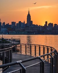 View of buildings at waterfront during sunset