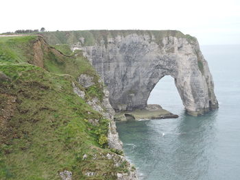 Rock formations by sea against sky