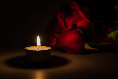 Close-up of lit candles in darkroom