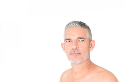 Portrait of shirtless man against white background