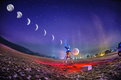 Digital composite image of illuminated field against sky at night