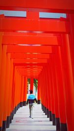 Rear view of woman walking in red building