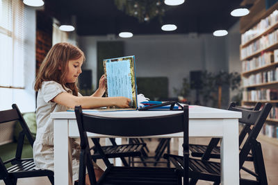 Young woman using laptop at cafe