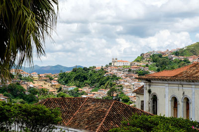 Houses in town against cloudy sky