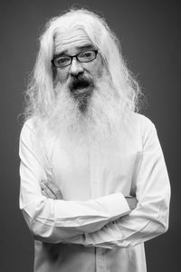 Portrait of man standing against black background