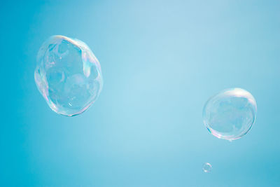 Close-up of bubbles against blue sky