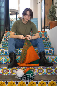 Portrait of young woman sitting on sofa at home