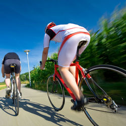 Man riding bicycle on road against sky