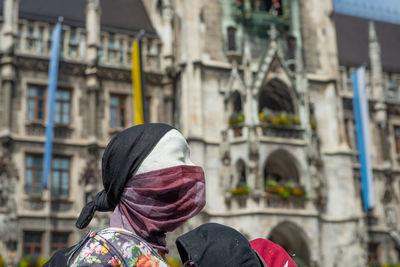 Rear view of woman standing against building