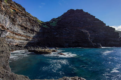 Rock formations in sea against sky