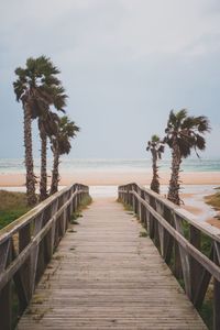 Pier on beach against sky