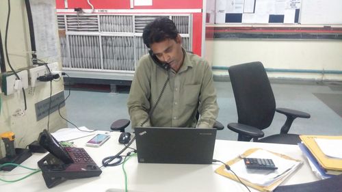 Man using mobile phone while sitting on table