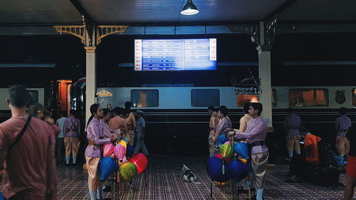 Rear view of people waiting on railway station platform
