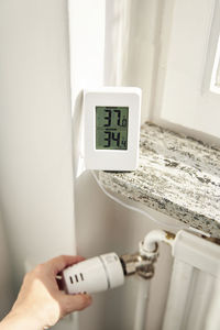 Woman adjusting radiator temperature