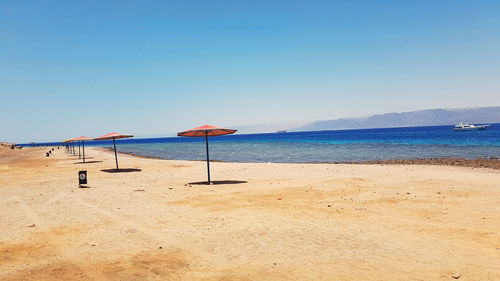 Scenic view of beach against clear blue sky