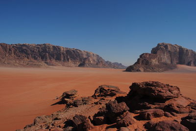 Scenic view of desert against clear blue sky