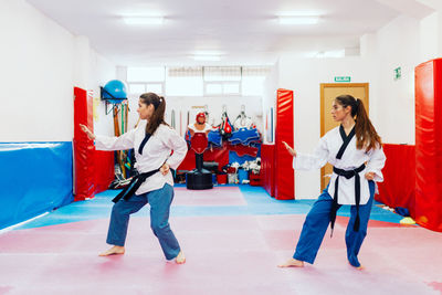 Full length of young women exercising on floor