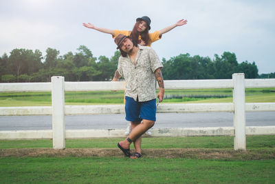 Full length of mid adult couple standing against sky