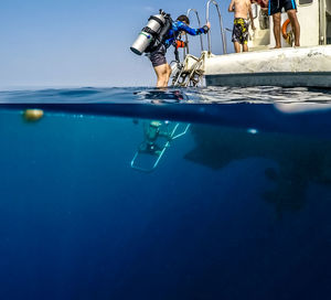 Man climbing ladder on boat during scuba diving