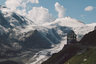 Snowcapped mountains against cloudy sky