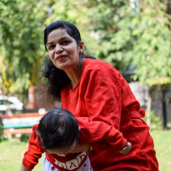 Loving mom carrying of her baby at society park. bright portrait of happy mum holding child