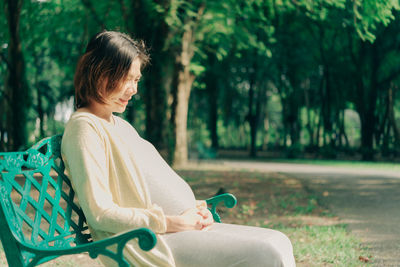 Pregnant woman sitting outdoors