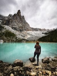 Rear view of woman looking at mountain against sky