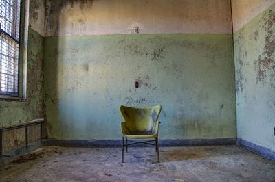 Empty chair on floor in abandoned house