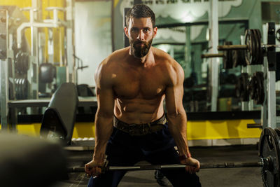 Full length of shirtless man smoking