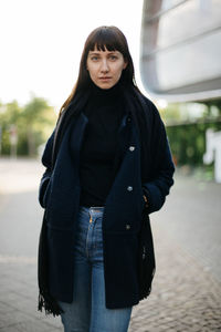 Portrait of young woman standing outdoors